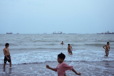 Families swim as ships are seen anchored in the Strait of Hormuz off the coast of Bandar Abbas, Iran. Getty Images
