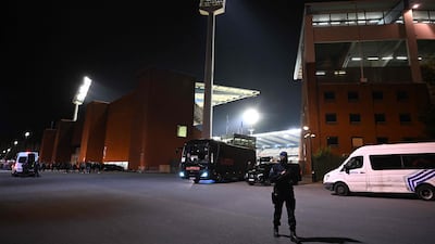 A police officer stand guards outside the King Baudouin Stadium, where Belgium v Sweden was abandoned at half-time once news of the fatal shooting had filtered through. AFP