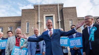 Reform UK leader Nigel Farage poses with winning councillors outside Havering Town Hall following the 2026 local election results in May. All photos: Getty Images
