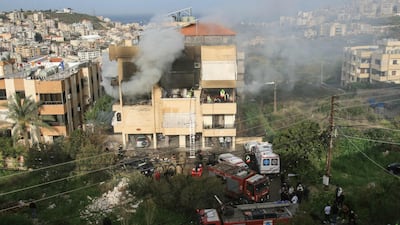 Emergency personnel tackle a fire after an apartment building in Haret Saida was hit. AFP