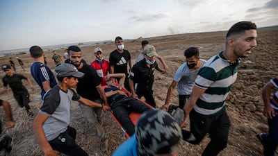 Palestinians carry a protester wounded during clashes with Israeli forces on Friday. EPA