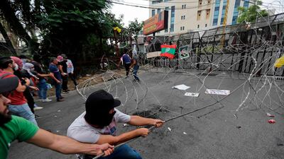Protesters pull barbed-wire fence off a street during an anti-US demonstration near the American embassy in Awkar, north-east Beirut. AFP