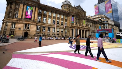 Pedestrians walk across Victoria Square decorated in preparation for the Birmingham 2022 Commonwealth Games. AP