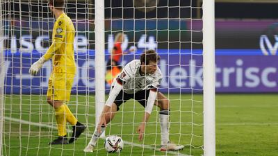 Thomas Muller picks up the ball after scoring Germany's eighth goal in a 9-0 2022 World Cup qualifying win over Liechtenstein, in Wolfsburg, northern Germany, on November 11, 2021. AFP