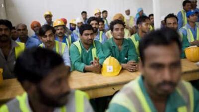 Workers at the Al Mamoura construction site wait for the UAE red Crescent and Ministry of Labour to distribute food and water.