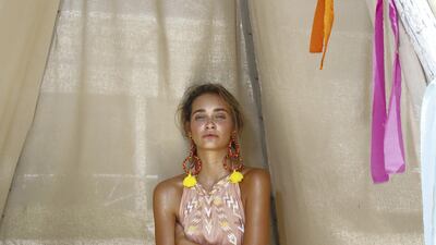 This summer dress features a neutral and feminine palette, speckled with white and yellow embroidery