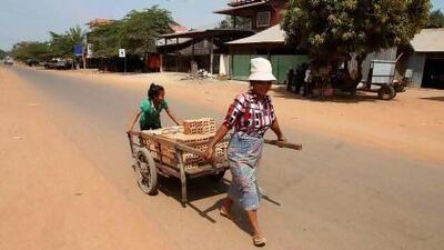 A woman and her daughter transport a cart of bricks in Rovieng. The remote district of Rovieng was once a battleground between Cambodian government troops and Pol Pot's genocidal Khmer Rouge. Samarang Pring / Reuters