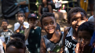 Children listen to a teacher at the First of May Refugee Camp, a squatters camp in Itaguai, Rio de Janeiro state, during the coronavirus pandemic. Thousands of illegal squatters have settled on land designated for a Petrobras refinery. AP Photo