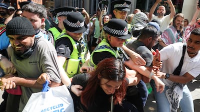 Police officers try to stop demonstrators from linking arms, during a protest against the group's designation as a terrorist organisation, in St Peter's Square in Manchester. Reuters