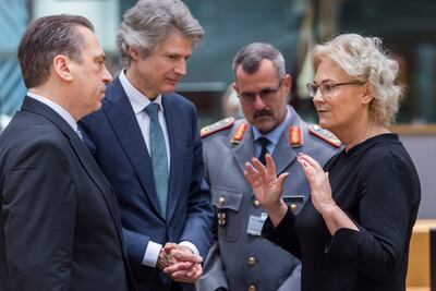 Germany Defence Minister Christine Lambrecht, right, talks with members of her cabinet as she arrives for a meeting at the EU Council building in Brussels. AP