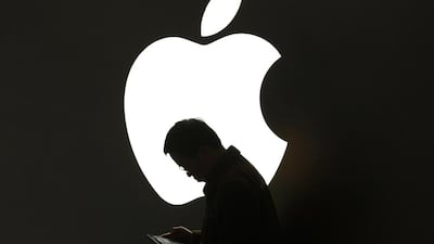 A man looks at his Apple device outside an Apple store in downtown Shanghai. Reuters
