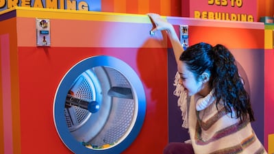 A girl peers inside a machine in the newly opened Launderette of Dreams