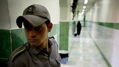 A guard stands along a corridor in Tehran's Evin prison. The prisoner is rarely out of Iranian headlines. It has a roll call of high-profile inmates, among them insiders of the regime caught in the crossfire of its feuding factions. Reuters
