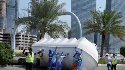 Workers attempt to move a large water tank that fell on Reem Island during the Abu Dhabi storm. Delores Johnson / The National