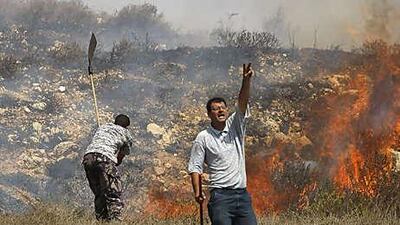 Palestinians in the West Bank village of Burin put out a fire in a field allegedly torched by Israeli settlers. The lack of Arabic translators hampers inquiries in such cases when the Israeli military police may have failed to act.