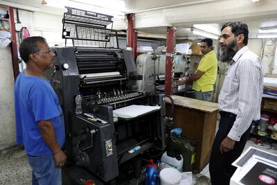 Naveed Baig (right) manages Al Mujahid Printing Press & Stationery in the Tourist Club area of Abu Dhabi. Pawan Singh / The National