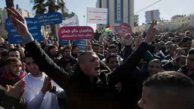 Protesters hold placards and chant anti-government slogans during a general strike in response to the Palestinian Social Security Law in the West Bank city of Ramallah. AP
