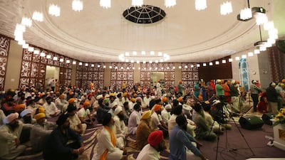 Devotees worship in the large central prayer room which houses the Guru Granth Sahib, the central religious text in Sikhism.