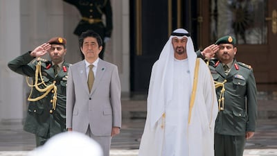 Sheikh Mohamed bin Zayed, Crown Prince of Abu Dhabi and Deputy Supreme Commander of the Armed Forces, and Shinzo Abe, Prime Minister of Japan (left), stand for the national anthem during a reception at the Presidential Palace in April 2018. Rashed Al Mansoori / Crown Prince Court - Abu Dhabi