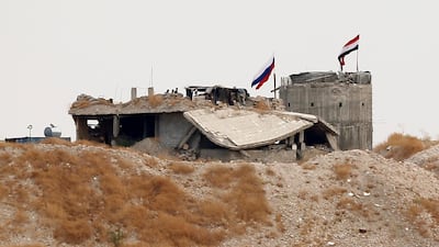 Russian and Syrian national flags are pictured near the northern Syrian village of Zor Magar, as seen from the Turkish border town of Karkamis in Gaziantep province, Turkey. REUTERS
