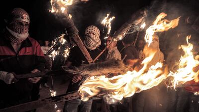 Palestinian protesters gather with torches during a demonstration against the outpost.