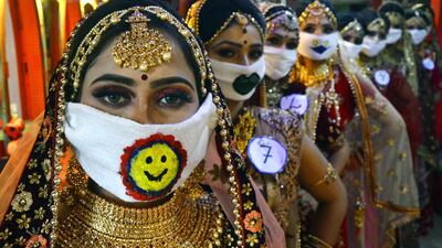 Participants of a beauty contest wearing symbolic masks pose for photographs in Jabalpur, India. EPA