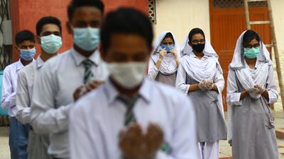 Pupils maintain physical distancing as they arrive on first day of school after the resumption of classes, in Karachi, Pakistan. EPA