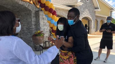 Nadia Williams, centre, is surprised to see her mother, Anita Turner, left, upon exiting a building at Park Springs elder care facility in Stone Mountain, Georgia. Workers who agreed to live at Park Springs to keep its residents safe from the coronavirus are back with their loved ones for the first time in nearly three months. AP Photo