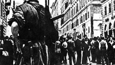 A German paratrooper armed with a submachine gun stands guard over a line of civilians in occupied Rome in 1944. Getty Images