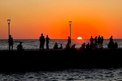 People gather along the corniche as the sun sets in the Libyan capital Tripoli. AFP