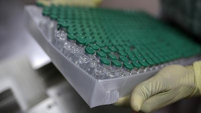 An employee handles vials of Covishield, the local name for the Covid-19 vaccine developed by AstraZeneca and the University of Oxford, on the production of line at the Serum Institute of India plant in Pune, Maharashtra, India. Bloomberg