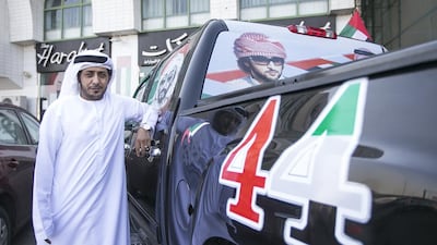 Ahmed Al Mansouri, who works at Abu Dhabi Civil Defence, shows off his pickup truck, which is festooned with National Day decals, at Harakat Auto Accessories. Mona Al Marzooqi / The National