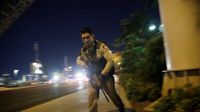 A police officer runs along a sidewalk near a shooting near the Mandalay Bay resort and casino on the Las Vegas Strip. John Locher / AP Photo