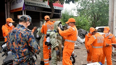 Members of India's National Disaster Response Force don protective gear at the site of a gas leak in Ludhiana, Punjab on Sunday. Reuters