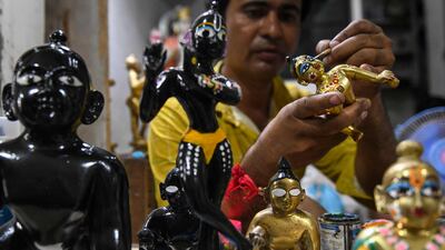 An artist applies finishing touches to an idol of Krishna at a workshop in Amritsar. AFP