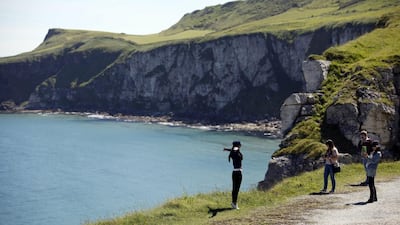 Tourists pose for photographs on the North Antrim coast close to Larrybane headland where Renly Baratheon's camp is located in Season Two of Game of Thrones. Peter Morrison / AP Photo