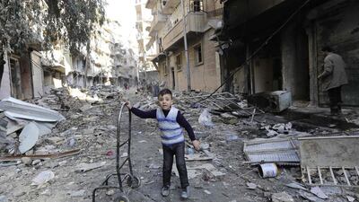 A Syrian boy stands amid the rubble.