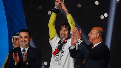 Iraq's national football team captain Jalal Hassan (C) lifts the Gulf Cup trophy as Prime Minister Mohammed Shia Al Sudani (L) and football federation president Adnan Derjal (R) applaud. AFP