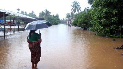 A woman stands on a flooded street in Kochi. EPA