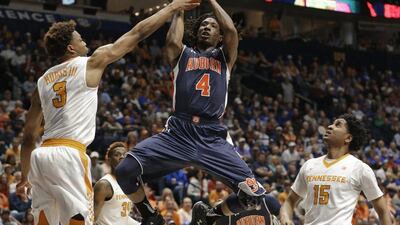 Auburn's TJ Dunans, centre, shoots between Tennessee's Robert Hubbs III, left, and Detrick Mostella during the first half of an NCAA college basketball game in the Southeastern Conference tournament in Nashville, Tenn., Wednesday, March 9, 2016. (AP Photo/Mark Humphrey)