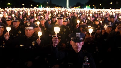 Policemen hold candles during the annual vigil to honour law enforcement officers who lost their lives in the line of duty, in Washington. AP