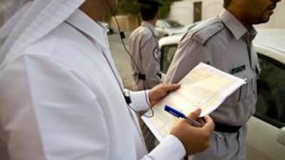 A zone inspector looks over notes regarding possible illegal villas near Muroor Road.