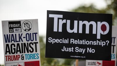Protesters hold placards during a demonstration outside Winfield House. Getty Images