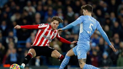 Brentford's Mathias Jensen challenges Manchester City's John Stones. Reuters