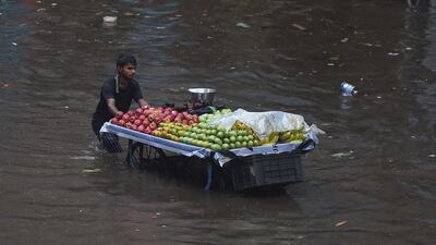 A fruit seller pushes his cart through a flooded street in Mumbai. AFP