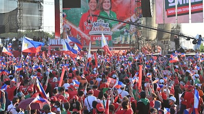 Supporters of Mr Marcos Jr and Ms Duterte wave flags during a campaign rally. AFP