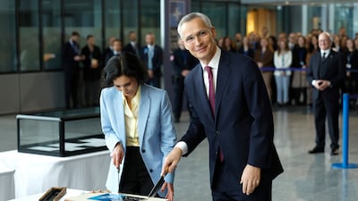 Nato Secretary General Jens Stoltenberg, right, and Belgium's Foreign Minister Hadja Lahbib cut a cake during a ceremony to mark the 75th anniversary of Nato at Nato headquarters in Brussels, Belgium. AP
