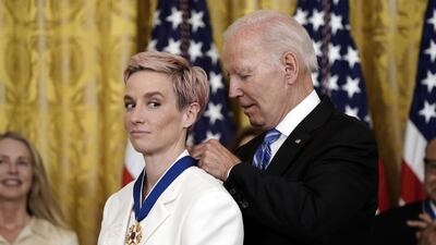 Mr Biden presents the award to footballer Megan Rapinoe, Olympic gold medalist and two-time Women's World Cup champion. UPI / Bloomberg