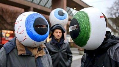Demonstrators wearing giant fake eyes hold a protest during a meeting of shareholders in commodities giant Glencore. AFP PHOTO / FABRICE COFFRINI