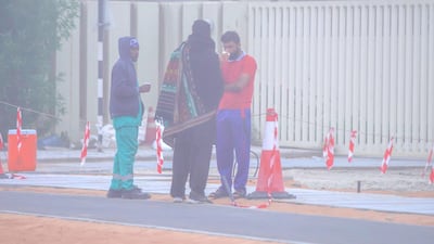 Workers drink tea before starting their day. Victor Besa / The National
